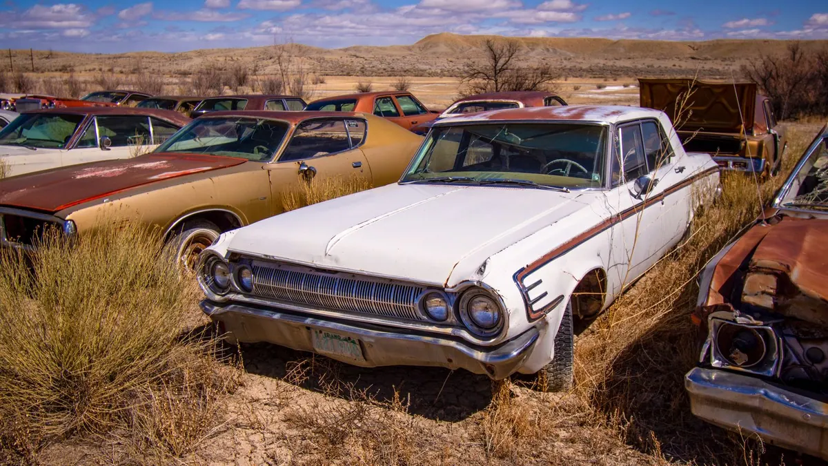 Voitures anciennes rouillées dans une casse