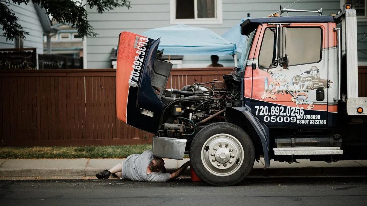 Mécanicien travaillant sous un camion dans la rue